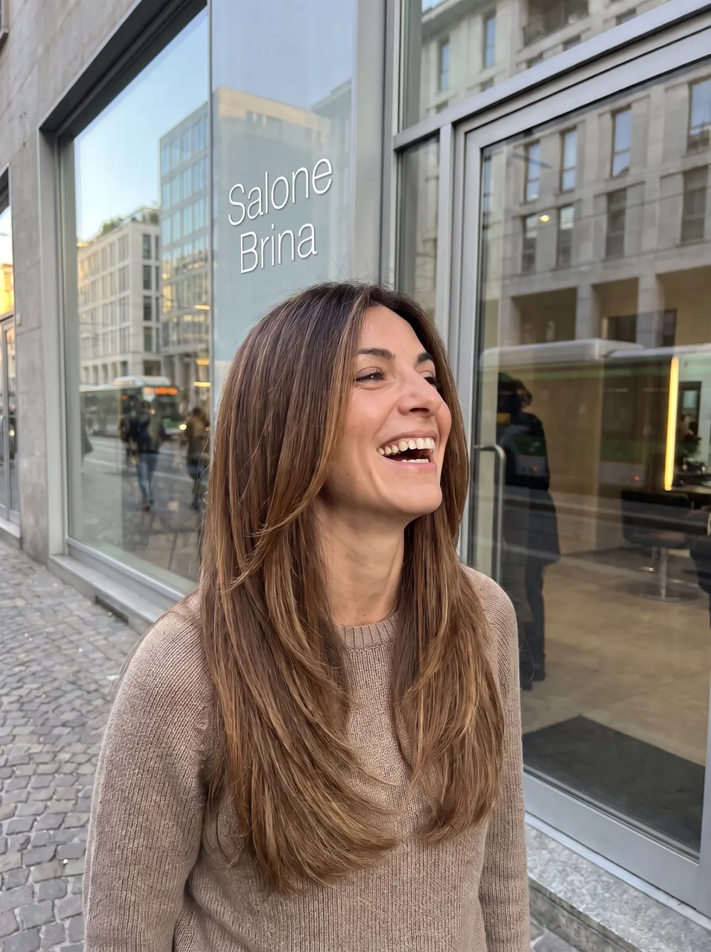 A client smiling outside the Salone Brina window