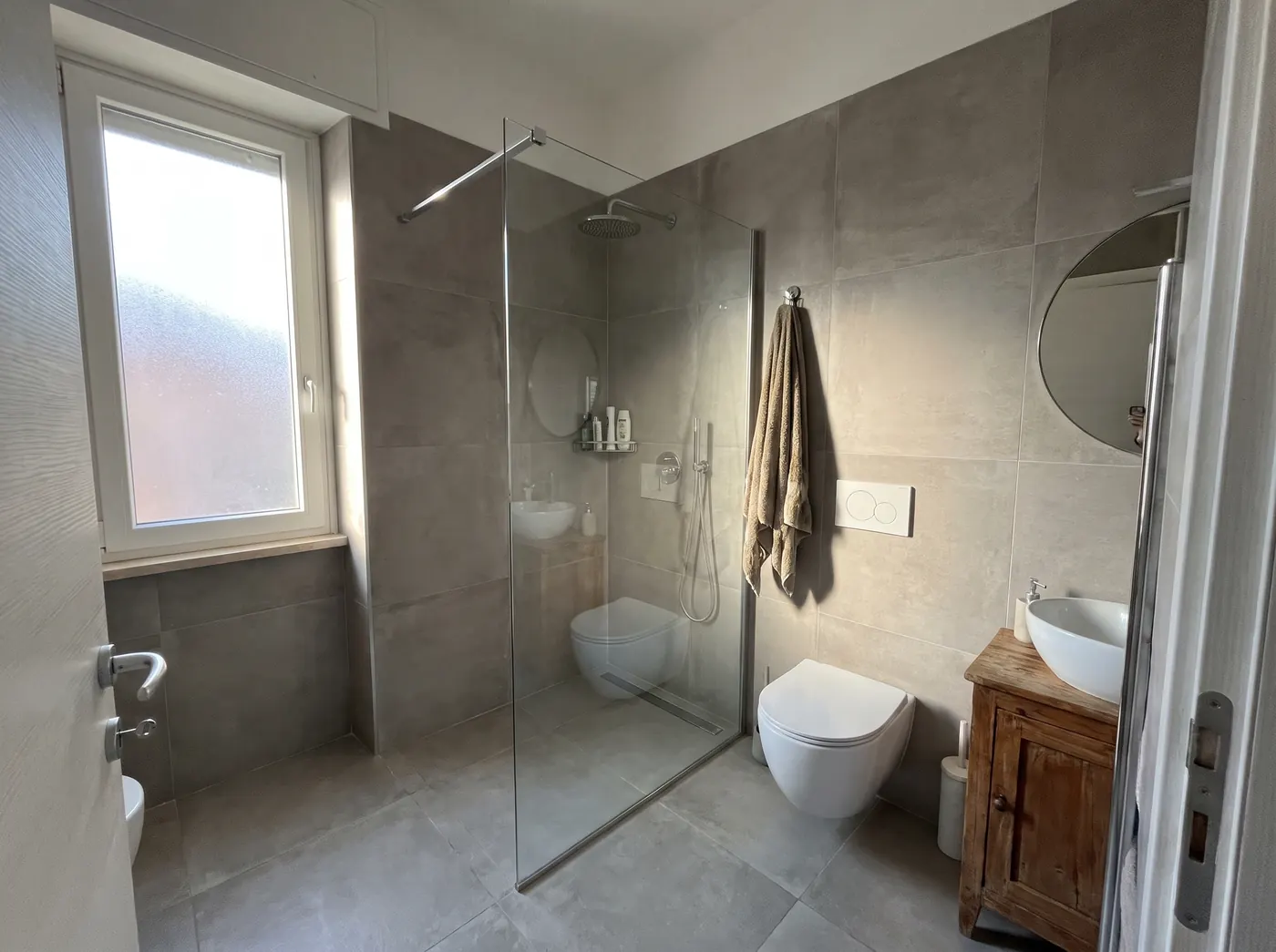 Newly renovated bathroom with walk-in shower and grey tiles