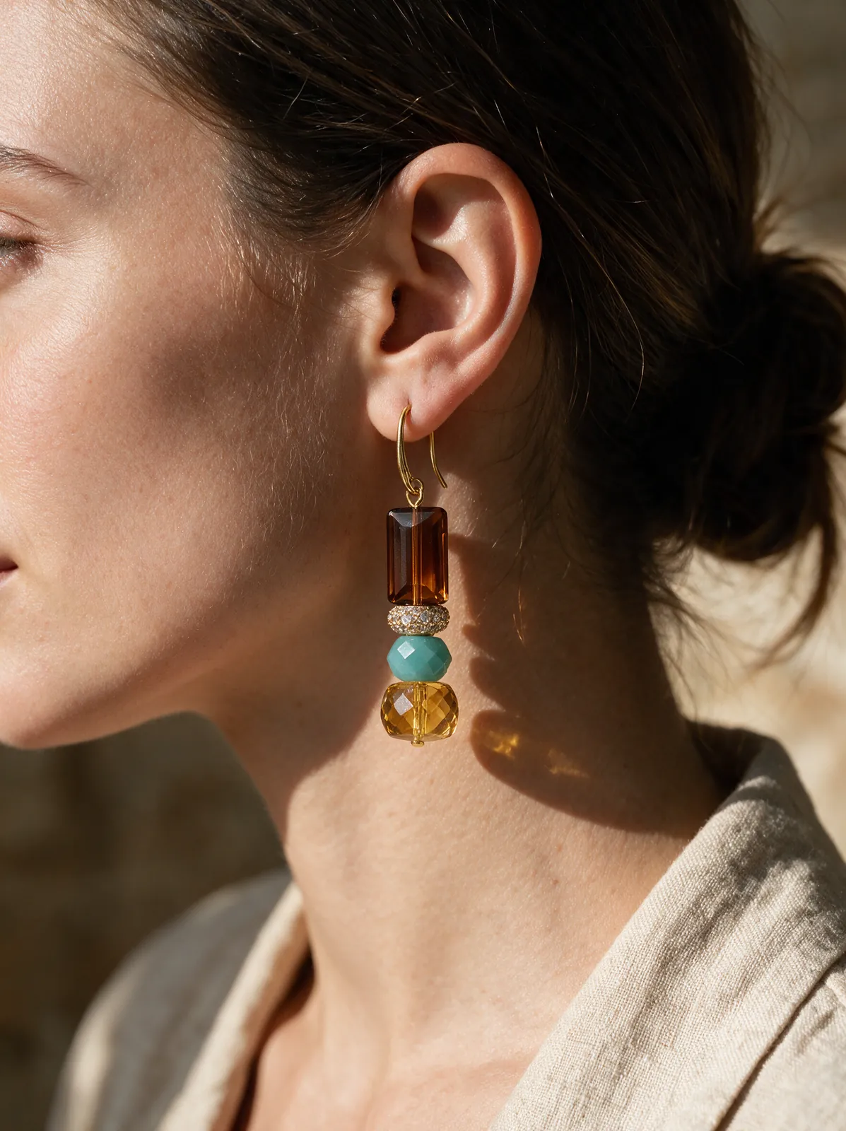 The earring worn by a model, seen in profile
